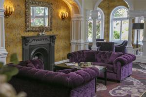 a living room with purple couches and a fireplace at Burlington Hotel, BW Premier Collection by Best Western in Folkestone +80 photos