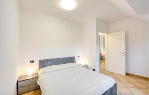 a white bedroom with a bed and two lamps at 2 Bedroom Nice Apartment In Uscio in Uscio