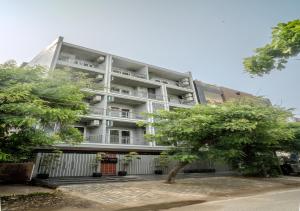 an apartment building with a tree in front of it at One Stayz by Zipcode in Gurgaon