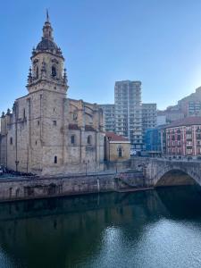an old building with a bridge over a river at Enea Living in Bilbao