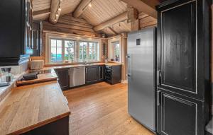 a kitchen with a stainless steel refrigerator and wooden floors at Nice Home In Lillehammer in Lillehammer