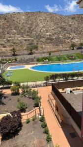 Una vista de dos piscinas en un resort. en Apartamento de lujo en Residencial El Mocan, en Palm-mar
