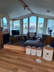 a living room with a couch and a table at 'THE HUT' 4 berth Caravan with cot bed in Ingoldmells