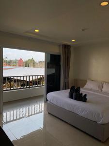 a bedroom with a large bed and a balcony at The Terraza A212 - Cozy apartment in Amphoe Koh Samui