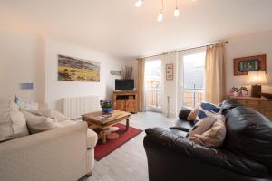 ein Wohnzimmer mit Sofa und Tisch in der Unterkunft Devon Beach Court, sea views of Woolacombe in Woolacombe