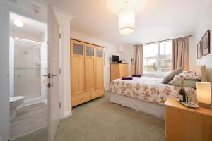 ein Schlafzimmer mit einem Bett und ein Badezimmer mit einer Toilette in der Unterkunft Devon Beach Court, sea views of Woolacombe in Woolacombe