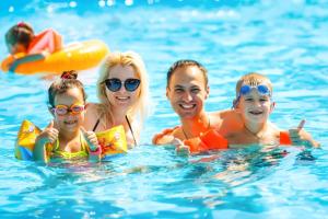 a family in the water at a swimming pool at Homely 8 Berth Caravan At Sunnydale In Lincolnshire Ref 35069S in Louth
