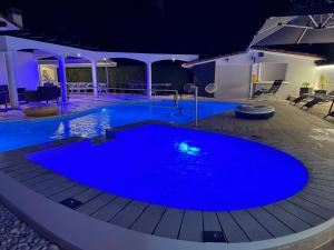 a large blue swimming pool at night at Villa Sany:10 Pers Maison 200m2 piscine , jacuzzi in Narrosse