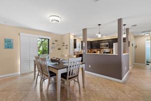 Una cocina y un comedor con mesa y sillas. en Pelican's Cove, en Port Orange
