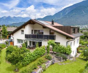 a house with a garden and mountains in the background at Alpenferienwohnung in Bürs +26 photos
