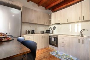 a kitchen with white cabinets and a table with chairs at Ariadne de Potie Maisonette - Chania Old Town in Chania