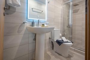 Un baño blanco con lavabo e inodoro. en Ariadne de Potie Maisonette, en La Canea