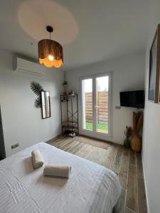 a bedroom with a white bed and a large window at La chambre de Bodhi 