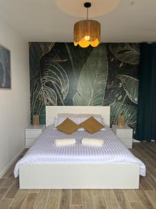 a white bed with two pillows on it in a bedroom at La chambre de Bodhi 