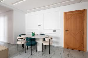 a white dining room with a white table and chairs at TT Holidays Rabat City Center Apartments in Rabat