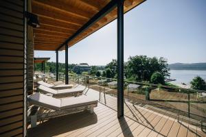 een terras met ligstoelen en uitzicht op het water bij Insel der Sinne - Das SeeDorf - Exklusive Ferienhäuser am Wasser in Görlitz
