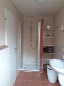 un bagno con doccia, WC e lavandino di *Davids - Ferienwohnung a Greetsiel
