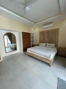 a bedroom with a large bed and a mirror at Luxury 3 Bed Villa in Kuta with Pool in Kuta Lombok +33 photos