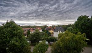 a group of houses and trees under a cloudy sky at Auenblick -Natur genießen, Leipzig erleben in Leipzig