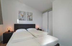 a bedroom with a large white bed with two lamps at Lovely Home In Heinkenszand With Heated Swimming Pool in Heinkensand