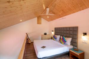 a bedroom with a bed and a wooden ceiling at goSTOPS Kasol PLUS, Manikaran Road - Private Rooms & Dorms in Kasol