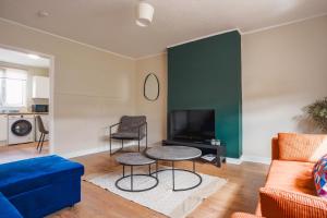 a living room with a blue couch and a tv at North Elgin Apartment in Clydebank