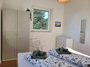 a bedroom with two beds and a window at Ferienwohnung Ankerplatz Wangen in Öhningen