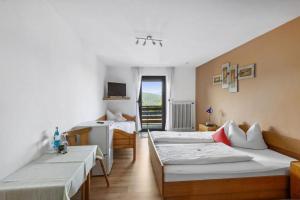 a room with three beds and a desk at Geräumiges Ferienhaus Mit Garten In Rittsteig in Neukirchen beim Heiligen Blut