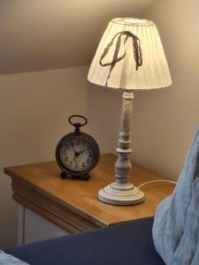 a table with a lamp and an alarm clock on it at Haus Waldstein Gipfelstürmer in Weißenstadt