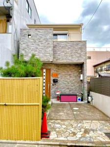 a house with a yellow fence and a pink garage at 夏様星 Cozy House near Kamogawa River in Kyoto