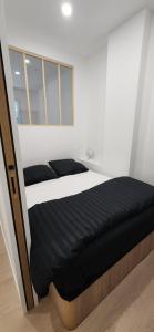 a bed in a white room with a window at Petit cocon au coeur Avignon in Avignon