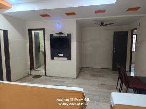 a waiting room with a tv on a wall at M R Hotels in Visakhapatnam