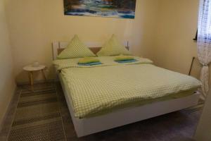 a bedroom with a bed with yellow sheets and green pillows at Haus Waldfrieden EG in Thalfang