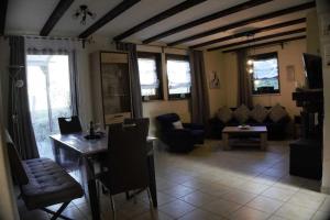 a living room with a couch and a table and chairs at Haus Waldfrieden EG in Thalfang