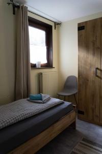 una camera da letto con un letto, una finestra e una sedia di Haus Waldfrieden EG a Thalfang Altre 14 foto