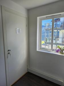 an empty room with a door and a window at White Cat Guesthouse in Ålesund