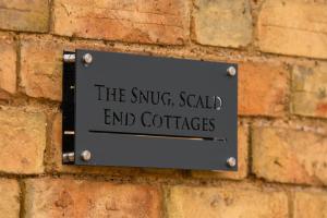 a sign on the side of a brick wall at The Snug in Bedford
