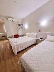 two beds in a hotel room with white sheets at Diamante Rosa Palace Hotel in Coromandel +24 photos