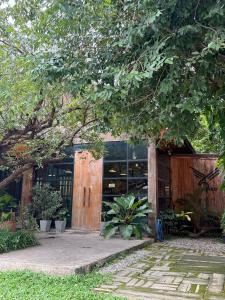 a building with a wooden door and some plants at YAYO coffee and bed in Chiang Rai