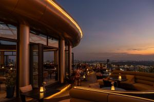 a rooftop bar with couches and tables on a building at Glow House Sukhumvit 54 in Bangkok