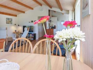 two vases with flowers sitting on a table at 5 person holiday home in Stege in Stege +24 photos