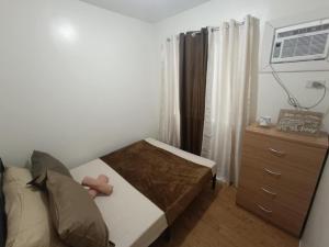 a small bedroom with a bed and a dresser at CK Condotel at Sanremo Oasis in Cebu City