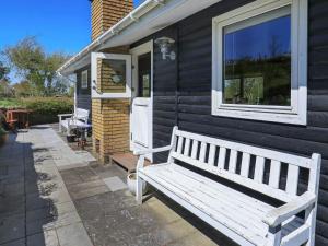 a white bench sitting outside of a house at 5 person holiday home in Stege in Stege