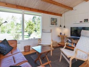 a living room with a couch and chairs and a tv at Tranquil Retreat at Ulvshale - By Traum Ferienwohnungen in Stege