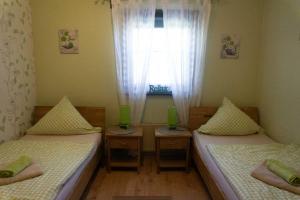 two beds in a small room with a window at Haus Im Wiesengrund OG in Thalfang
