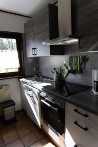 a kitchen with a sink and a stove top oven at Haus Im Wiesengrund OG in Thalfang +9 photos