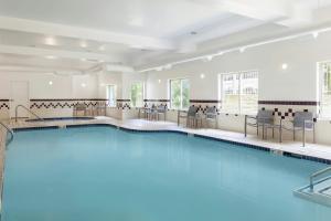 a large swimming pool with chairs and a table at Springhill Suites by Marriott Frankenmuth in Frankenmuth