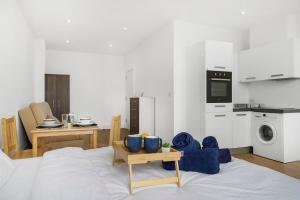 a living room with a kitchen and a large bed at Lovely Private Large Studio with Parking in Borehamwood