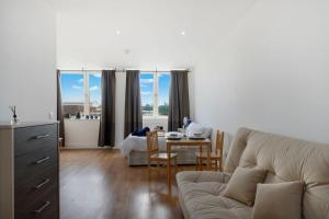 a living room with a couch and a table at Lovely Private Large Studio with Parking in Borehamwood +9 photos