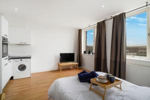 a bedroom with a bed with a table and a window at Lovely Private Large Studio with Parking in Borehamwood